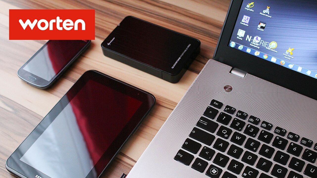 Móvil, tableta y ordenador en una mesa y el logotipo de Worten